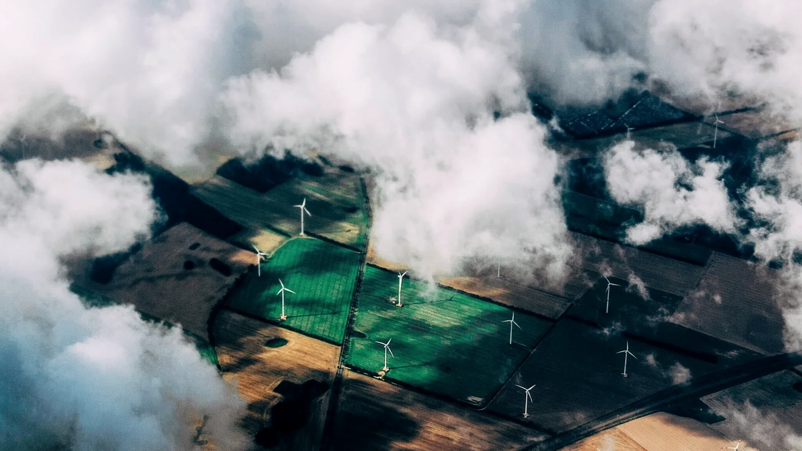 Wind turbines partly visible through cloud.